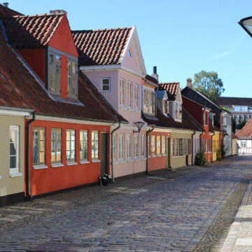 Colourful old houses in the narrow streets of central Odense, explore the hometown of H.C. Andersen from charming city lodgings