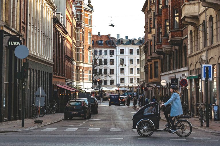 Street view in Vesterbro, Copenhagen with cyclists, pedestrians, and cars - central area with holiday apartments